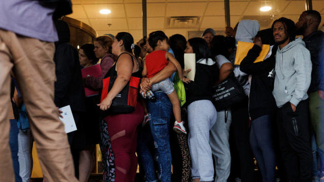 A group of migrants and members of the public wait in line outside an Illinois Department of Human Services office on Sept. 25, 2023, in Chicago. 