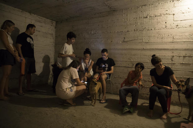 People take refuge in a shelter as sirens are heard on October 7, 2023, in Tel Aviv, Israel. 